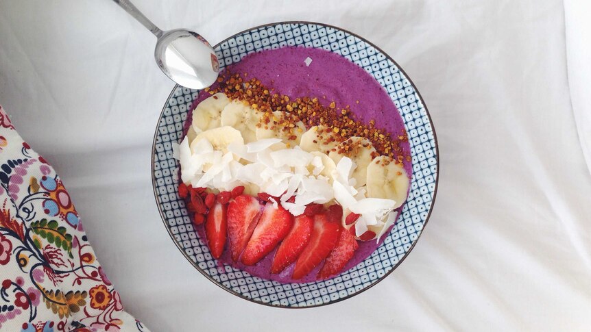 A raw smoothie bowl with banana, coconut and  strawberries.