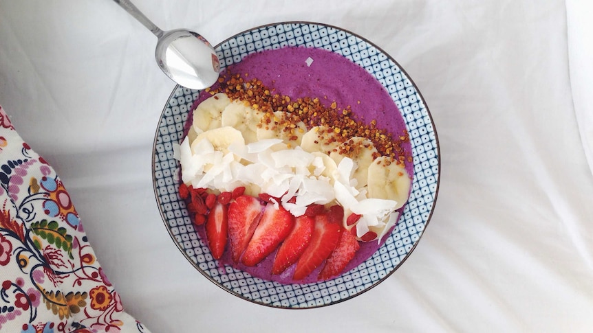 A raw smoothie bowl with banana, coconut and  strawberries.