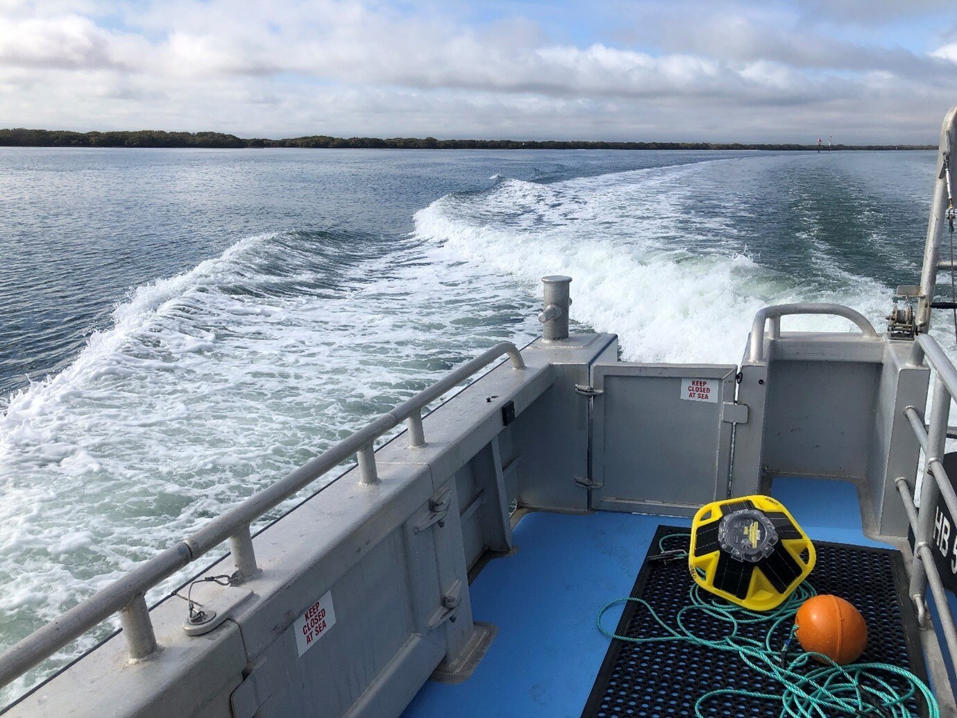 A yellow buoy sits on the deck of a boat.