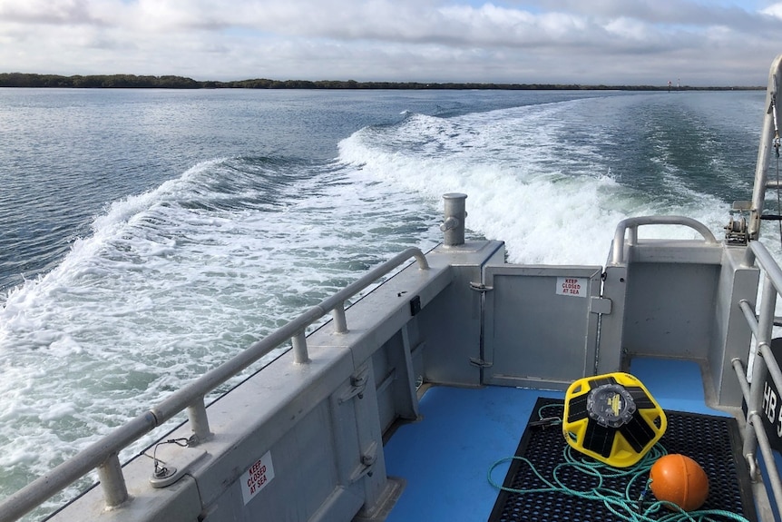 A yellow buoy sits on the deck of a boat.