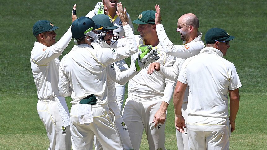 Nathan Lyon is congratulated by his cricket colleagues