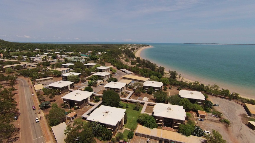 A drone photo of the town of Nhulunbuy. Blue water is in the background.