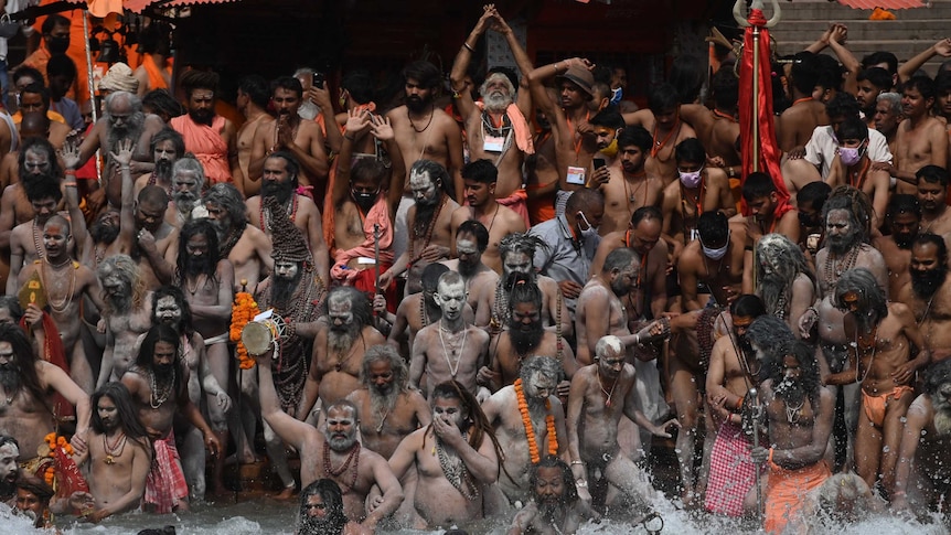 Hindu holy men take a holy dip in the waters of the Ganges River during the religious festival, Kumbh Mela.