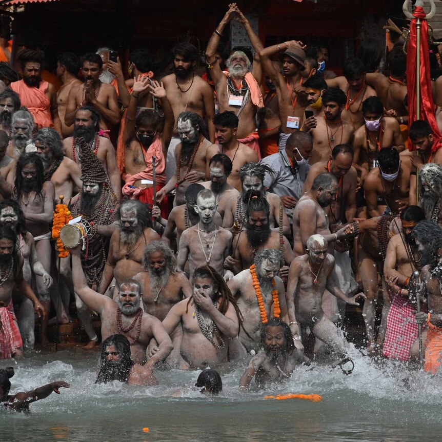 Hindu holy men take a holy dip in the waters of the Ganges River during the religious festival, Kumbh Mela.