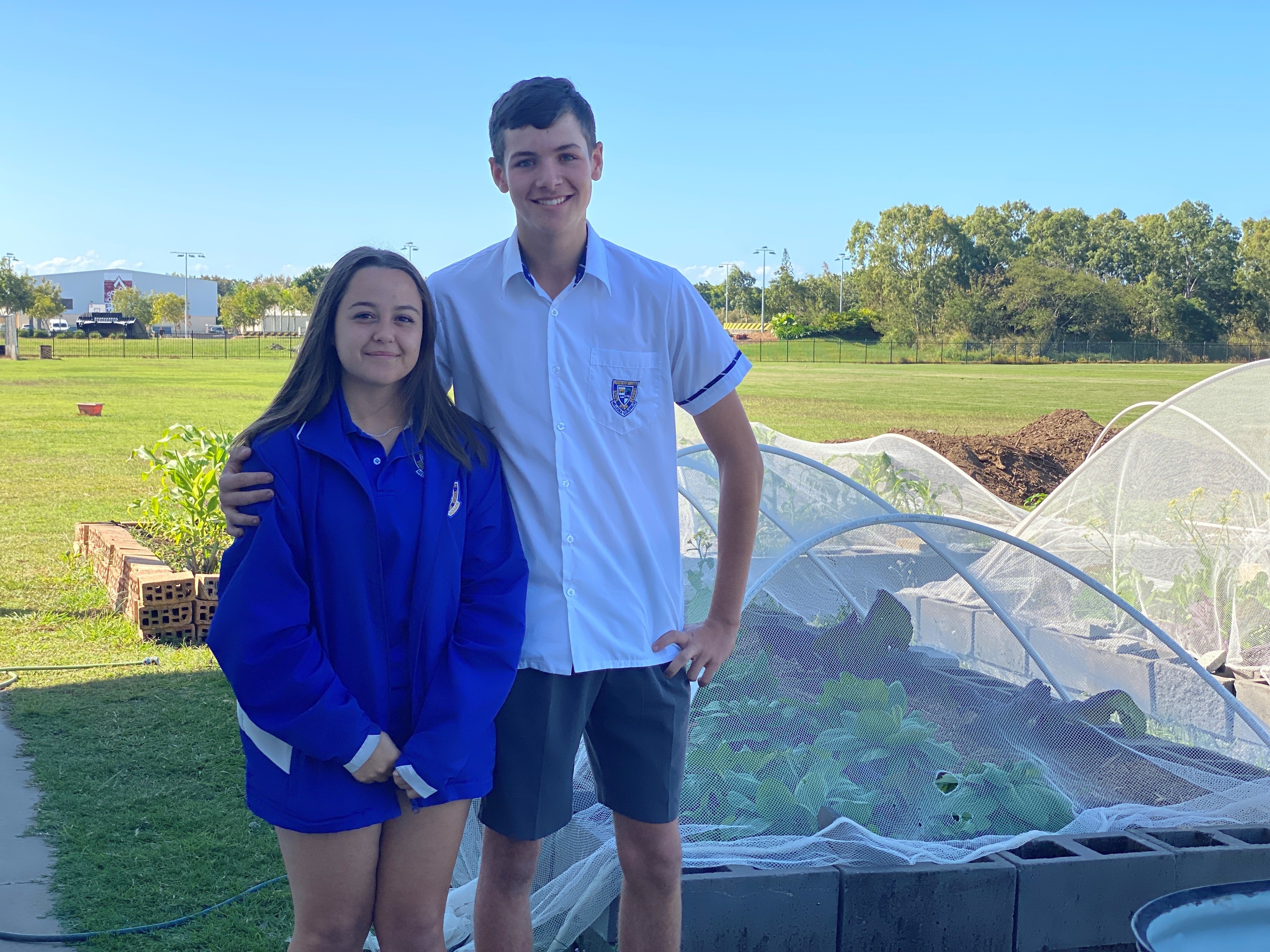 Tamlyn Nell and Aaron Bickford standing in front of gardens at Mackay North State High School 