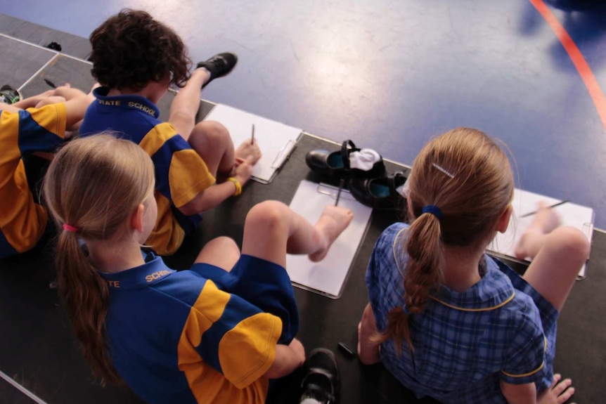 Young Queensland students attempt to draw with their feet like thalidomide survivor and artist Trish Jackson.