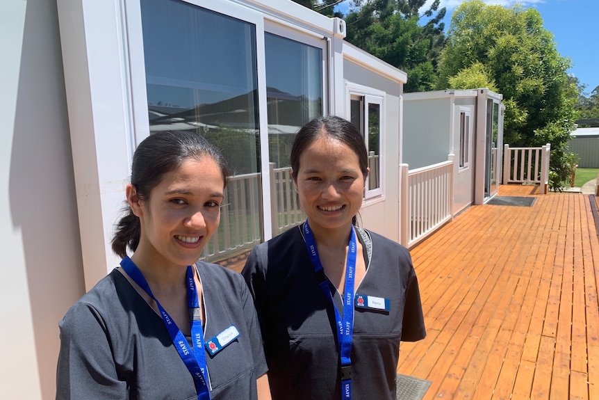 Nurses in front of tiny homes