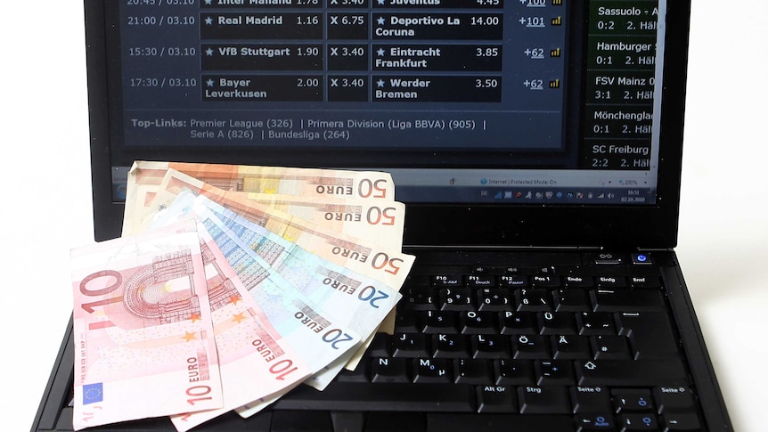 Photo illustration shows Euro bank notes with a laptop signed into an internet betting webpage.