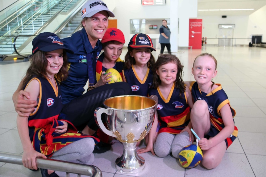 Adelaide Crows co-captain Chelsea Randall with young fans at Adelaide airport.