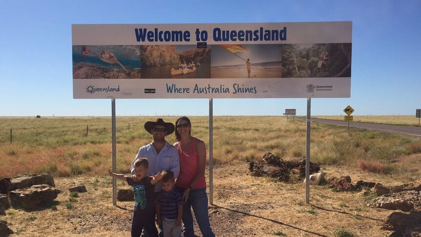a family standing in front of a sign