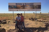 a family standing in front of a sign