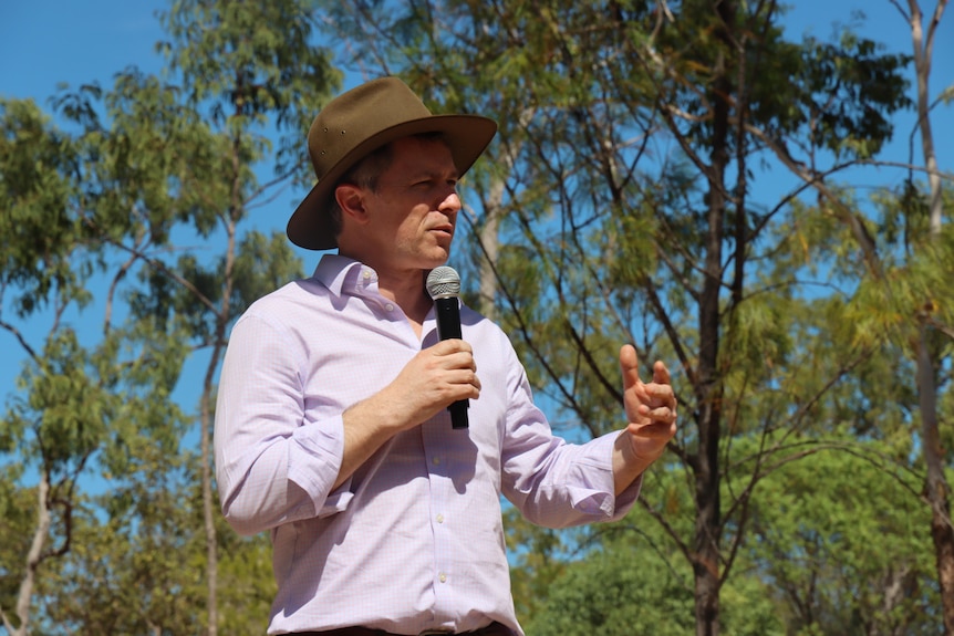 Jason Clare speaks with a microphone.