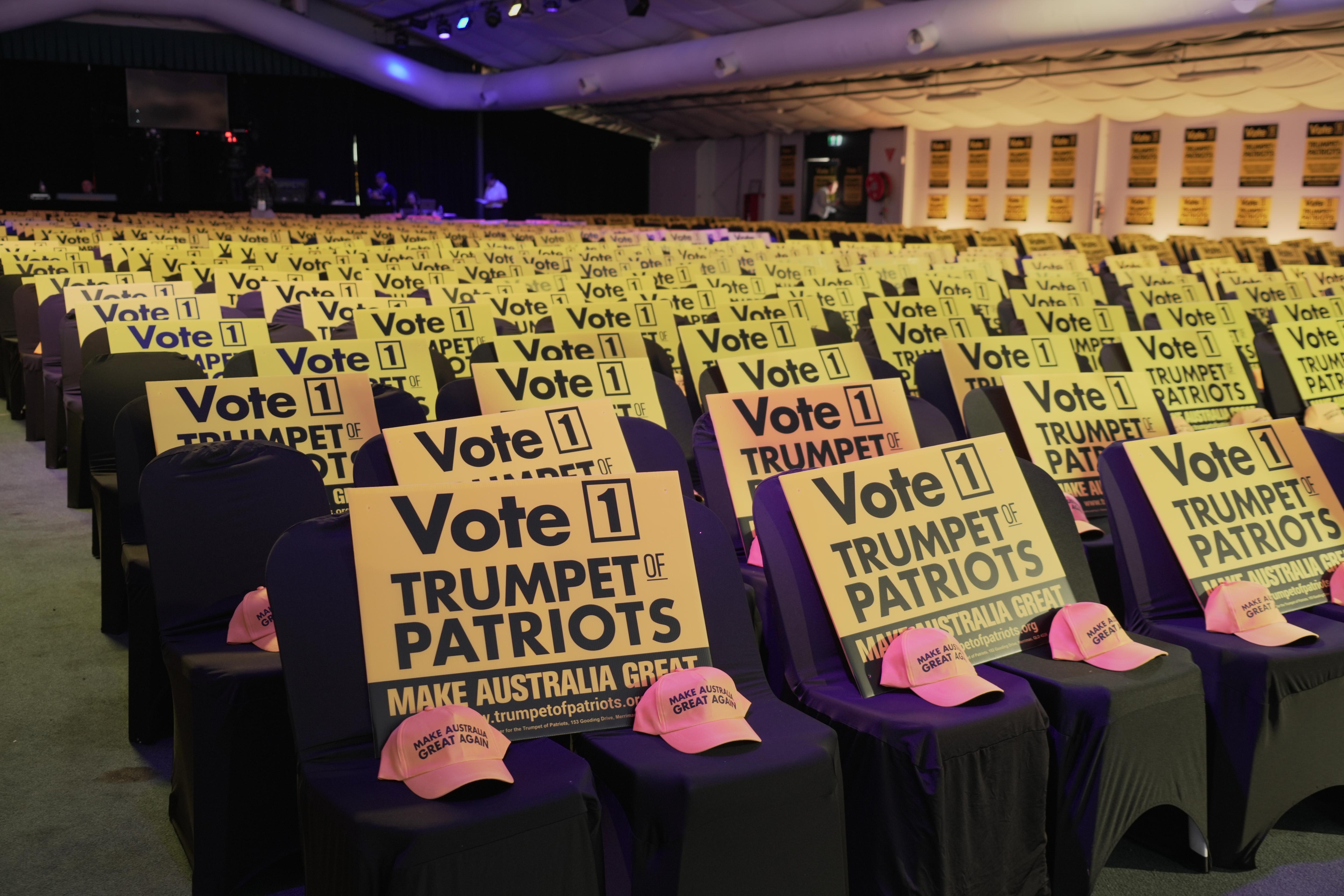 A row of chairs that have caps and signs on them that read 'Make Australia Great Again'.