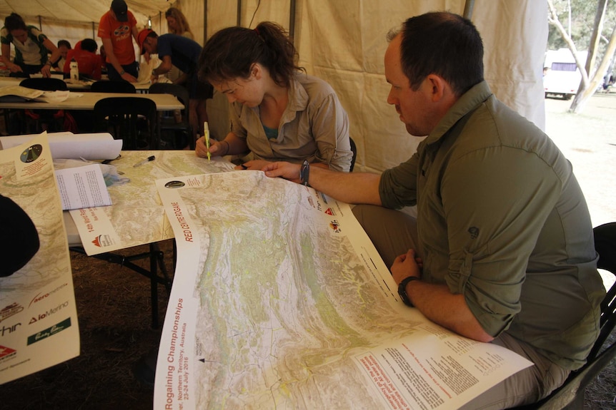 Competitors look over a map of the Red Centre course
