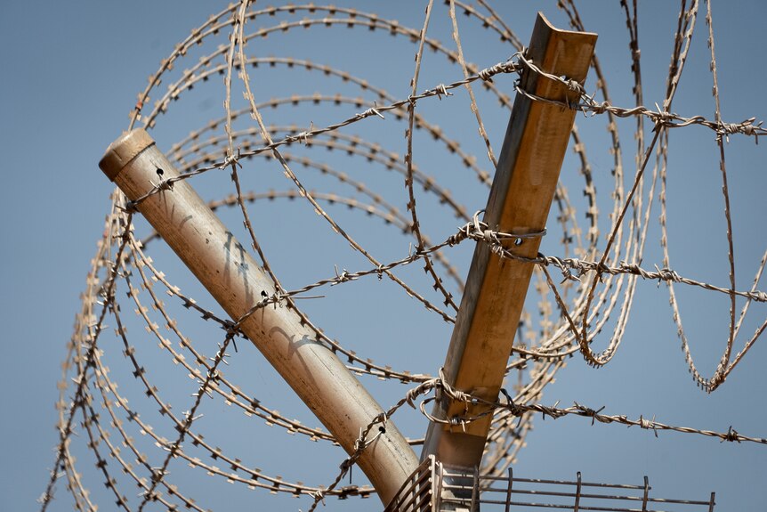 Barbed wire rims Wadeye’s fortified police compound.