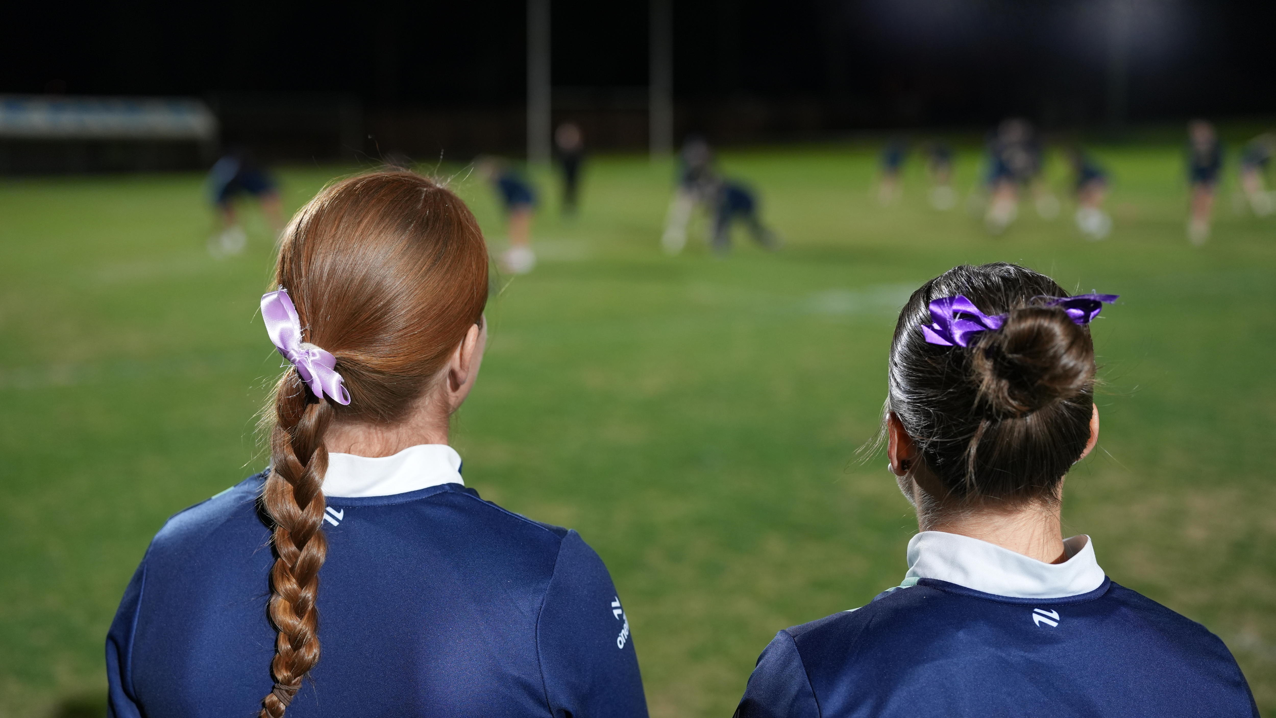 two women with purple ribbons in hair