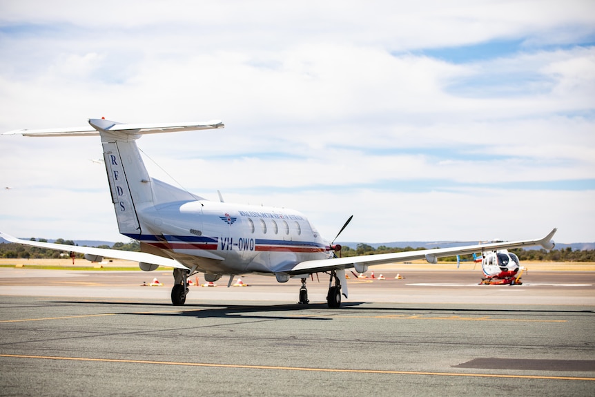 A plane sitting on the tarmac from behind.