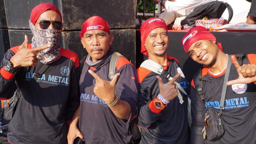 A group of men in bandanas pose for the camera