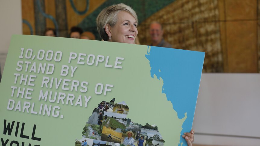 Minister for Environment Tanya Plibersek holds a sign that says people of the darling.