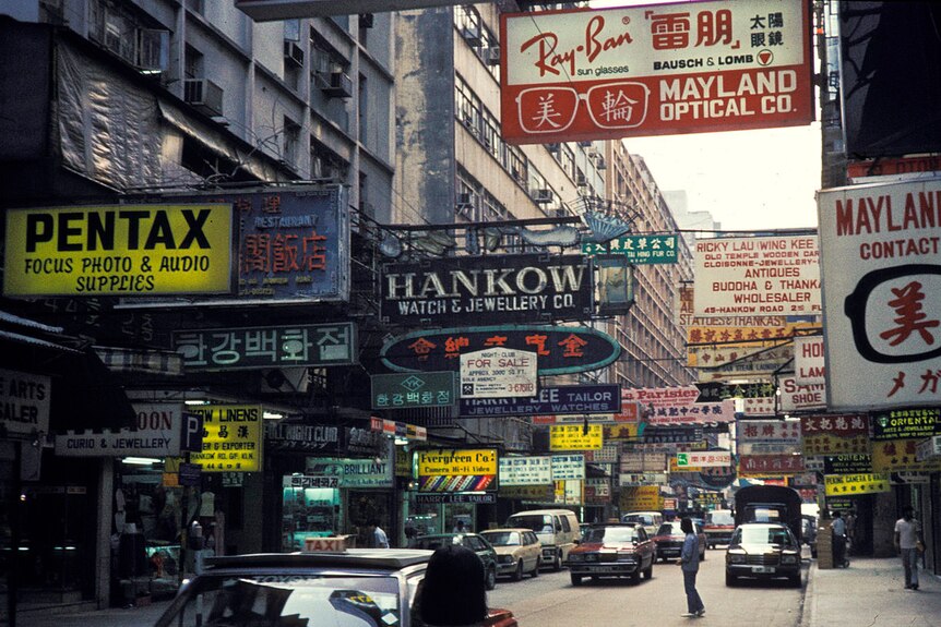 A shopping street with signs for Western brands like Pentax and Ray-Ban