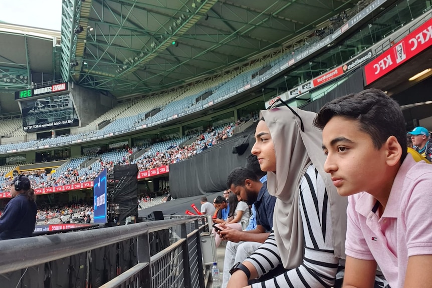 Picture of a young boy and a girl in a cricket stadium