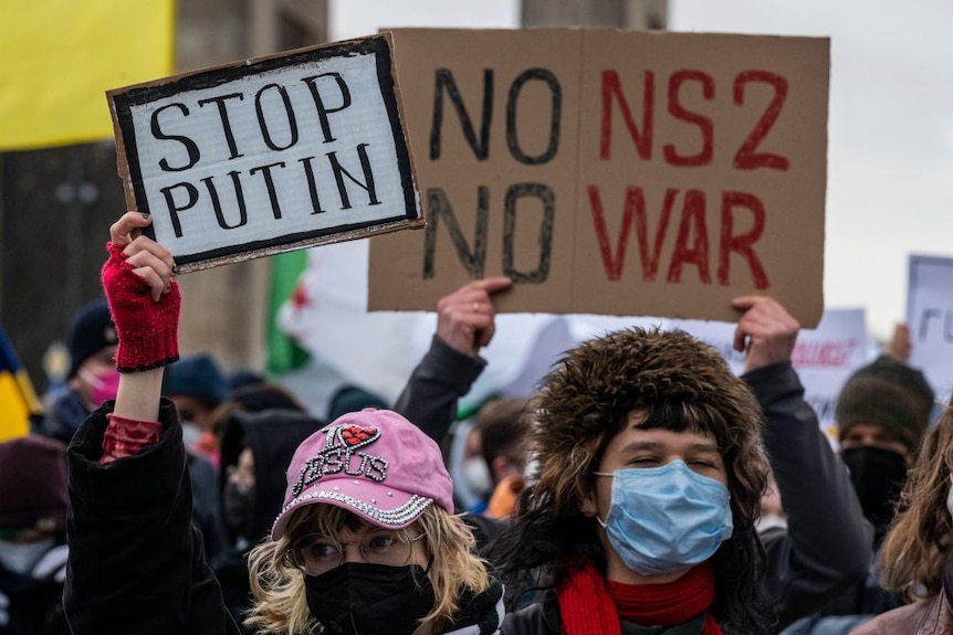 A protester holds a banner reading 'No Nordstream 2, No war' in opposition to the Russia-Europe gas pipeline & war in Ukraine