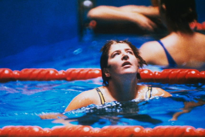 A female swimmer looks up while in the pool at the 1964 Tokyo Olympics.
