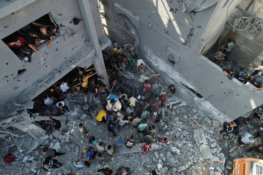 Palestinians search for casualties, at the site of Israeli strikes on houses, amid ruins.