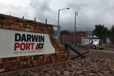 The exterior wall of Darwin Port with signage in red and white and a truck in the background.