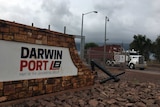 The exterior wall of Darwin Port with signage in red and white and a truck in the background.