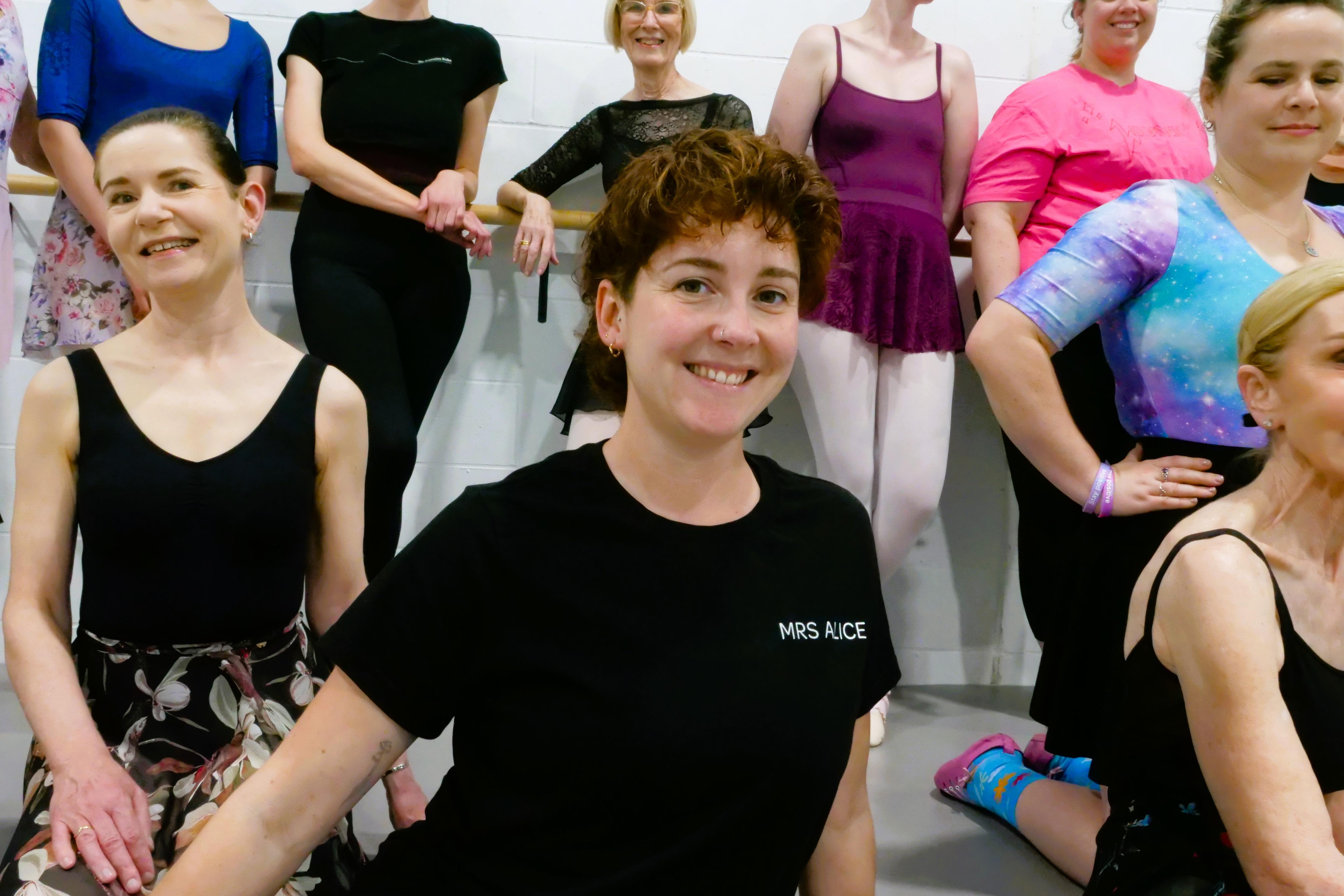 Alice sits in front of a group of her students in the studio