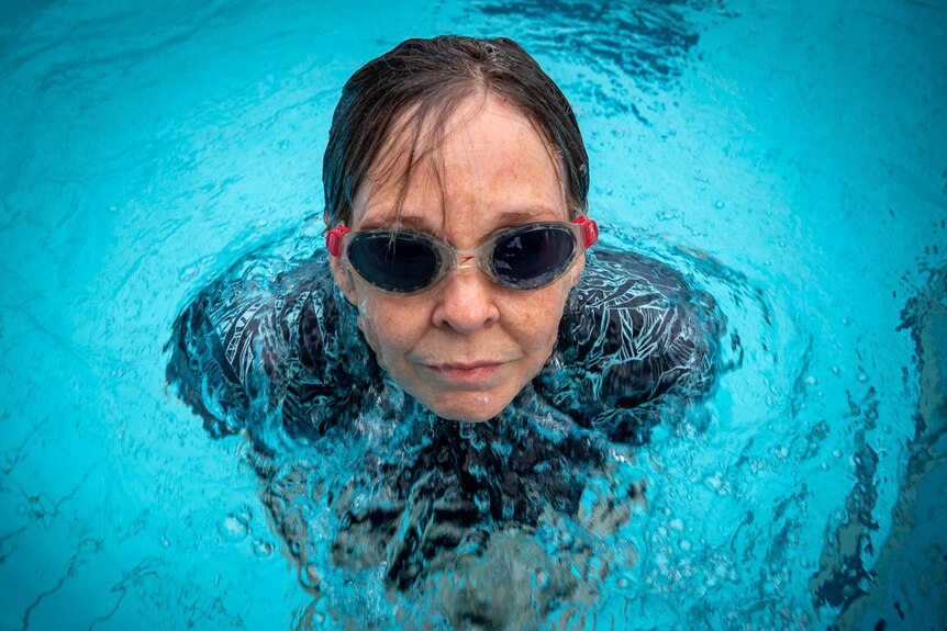 Rebecca Smyth comes up out of the water while swimming at her local pool in Adelaide.