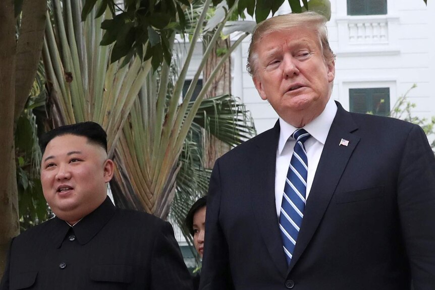 Donald Trump looks away while walking with North Korean leader Kim Jong-un.