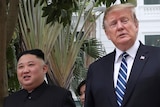 Donald Trump looks away while walking with North Korean leader Kim Jong-un.