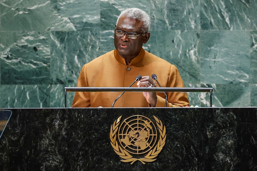 Manasseh Sogavare speaking behind a lectern with the UN logo. 