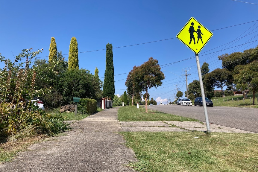 A sunny path on the side of a street.