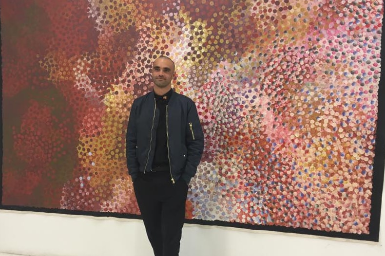 Otis Carey stands in front of one of his paintings at an earlier exhibition