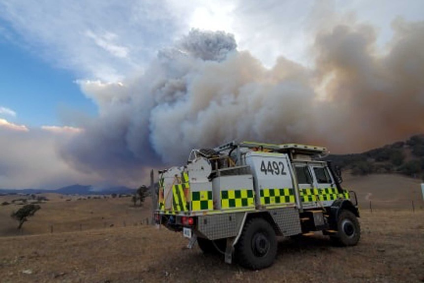 A large cloud of smoke is behind a fire truck