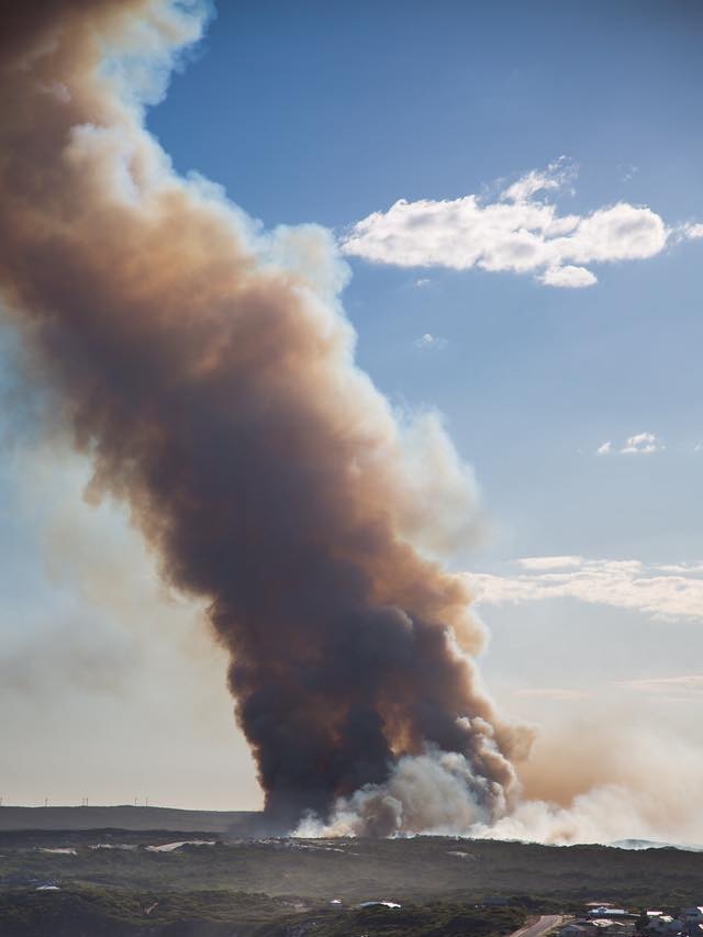 A plume of smoke rises into the sky from a burning bushfire.