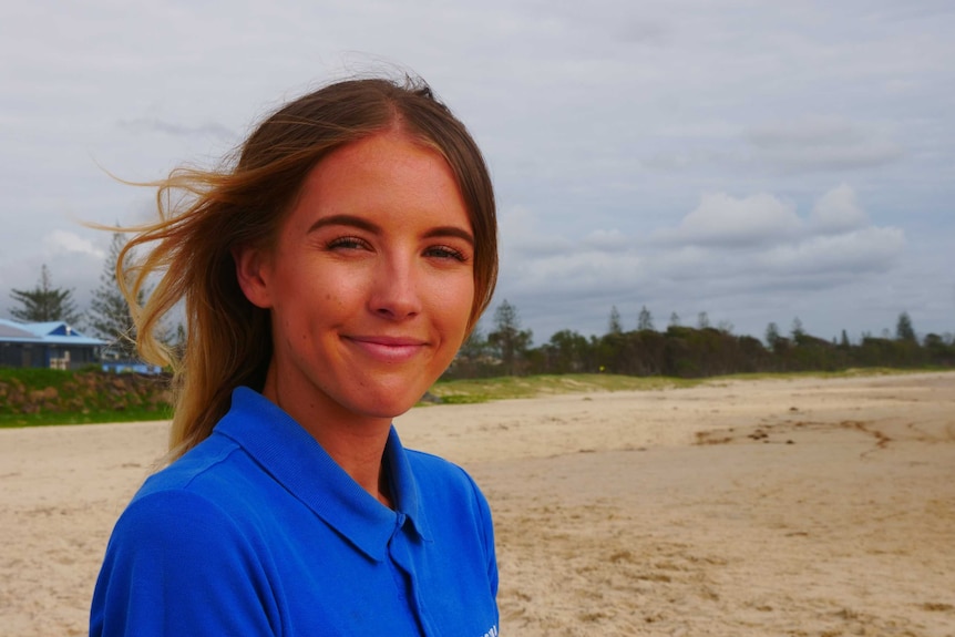 Woman at beach smiling.