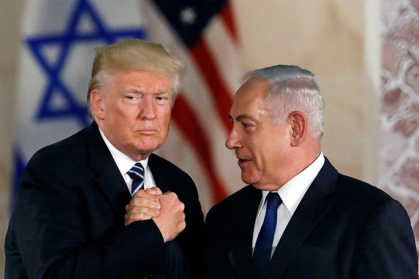 Donald Trump and Benjamin Netanyahu shake hands.