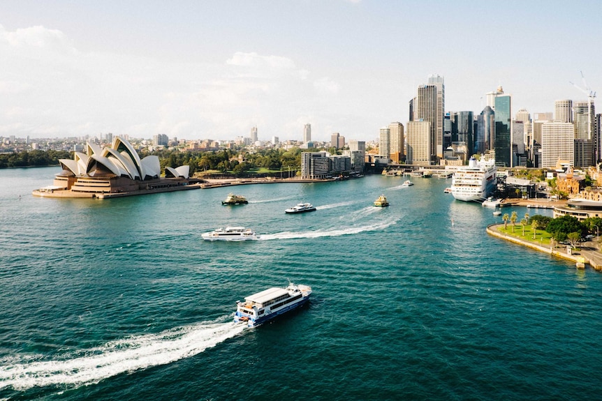 A view across the water of the Sydney Opera House on the left, with the city central business district on the right.