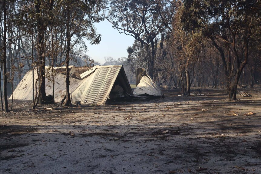 Roof from destroyed building on the ground after a bushfire swept through a property near Noosa.