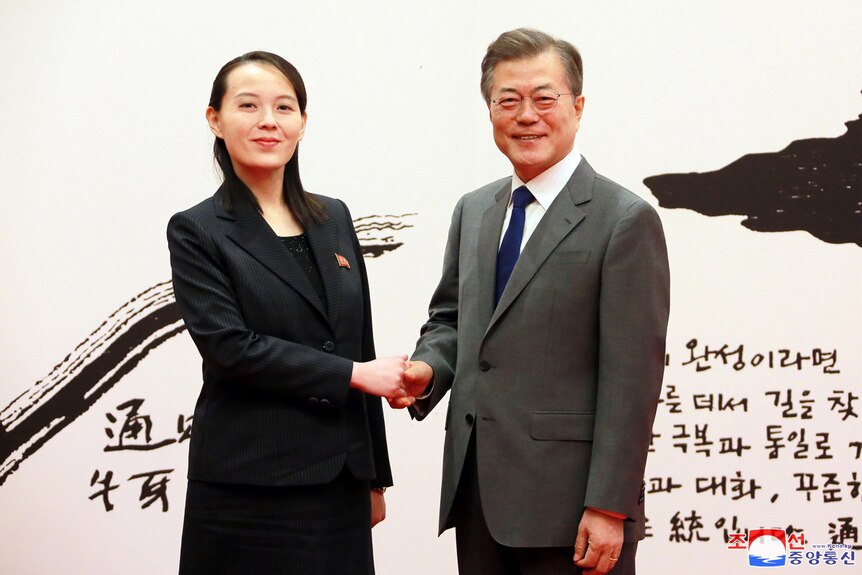 A North Korean woman in her 30s shakes hands with a middle-aged South Korean man.