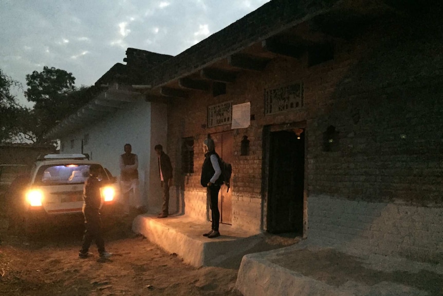 The Foreign Correspondent crew wait in a small village