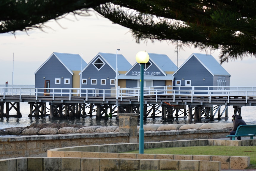 Grey and white shacks built on a pier over the water in Busselton.