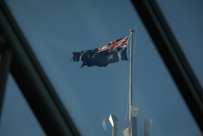 A tattered flag flying high above Parliament House
