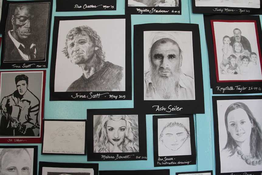 A range of portraits on an aqua-coloured wall.