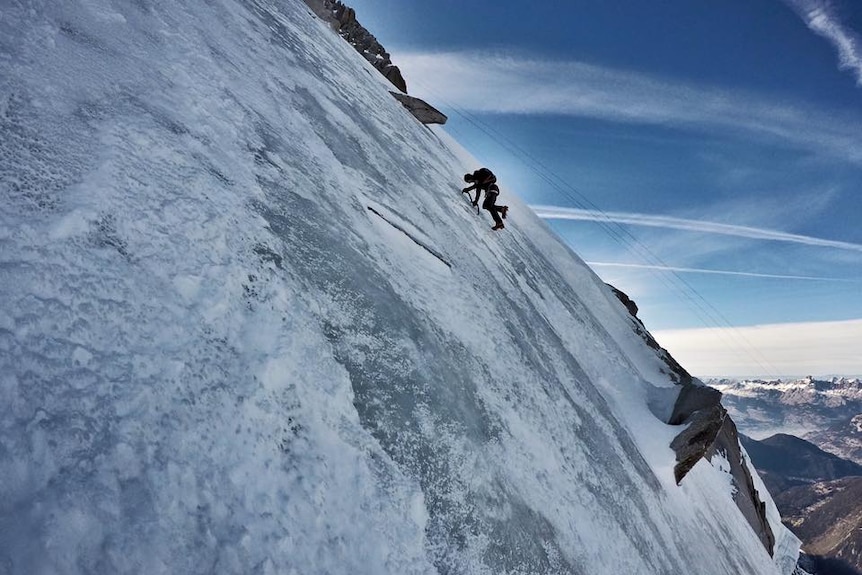Ueli Steck clings uses ice picks as he traverses an icy mountain