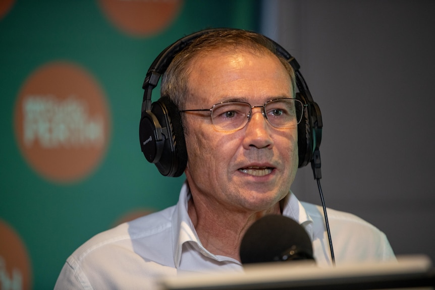 Roger Cook in the ABC Radio Perth studio with headphones on